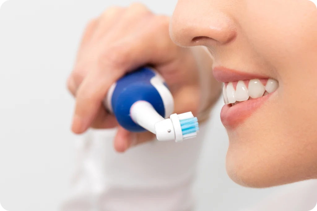 Brossage des dents à la brosse électrique, gros plan sourire